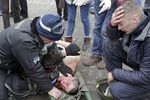 Раненому участнику столкновений оказывают помощь на площади Независимости в Киеве