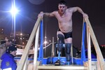 Верующий во время крещенских купаний на берегу Енисея возле Свято-Никольского храма-памятника в Красноярске, 19 января 2025 год