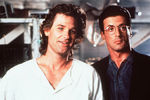 <b>Кадр из фильма «Танго и Кэш» (1989)</b> <br>
В 1989 году Курт Рассел снялся вместе с Сильвестром Сталлоне в фильме режиссера Андрея Кончаловского «Танго и Кэш». Несмотря на то, что это был уже пятый англоязычный проект постановщика из СССР, продюсеры не разрешили ему довести работу над фильмом до конца. Сам Кончаловский позднее с теплотой вспоминал о работе со звездами голливудских боевиков.