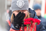 Жительница города с цветами у торгово-развлекательного центра «Зимняя вишня»