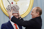 Президент России Владимир Путин надевает копию императорской короны на художественного руководителя московского Театра эстрады Геннадия Хазанова в честь его 70-летнего юбилея во время встречи в Кремле, 2015 год
