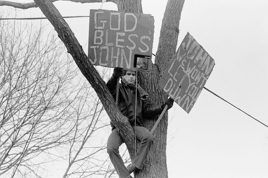 Фанат Джона Леннона держит плакаты, на&nbsp;которых написаны призывы к&nbsp;Богу о&nbsp;благословении усопшего, во время панихиды в&nbsp;память о&nbsp;музыканте (более 50 000&nbsp;человек пришли почтить память бывшего солиста группы Beatles) в&nbsp;Центральном парке Нью-Йорка, 14&nbsp;декабря 1980&nbsp;года