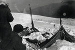 Палатка группы Дятлова, частично раскопанная от снега. Фото участника поисков А. С. Чеглакова (по другим сведениям, В. Д. Брусницына). Слева от палатки поисковики: Ю. Коптелов, за ним В. Карелин