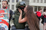 Сотрудник силовых структур Белоруссии и участница демонстрации около Дома правительства в Минске, 14 августа 2020 года