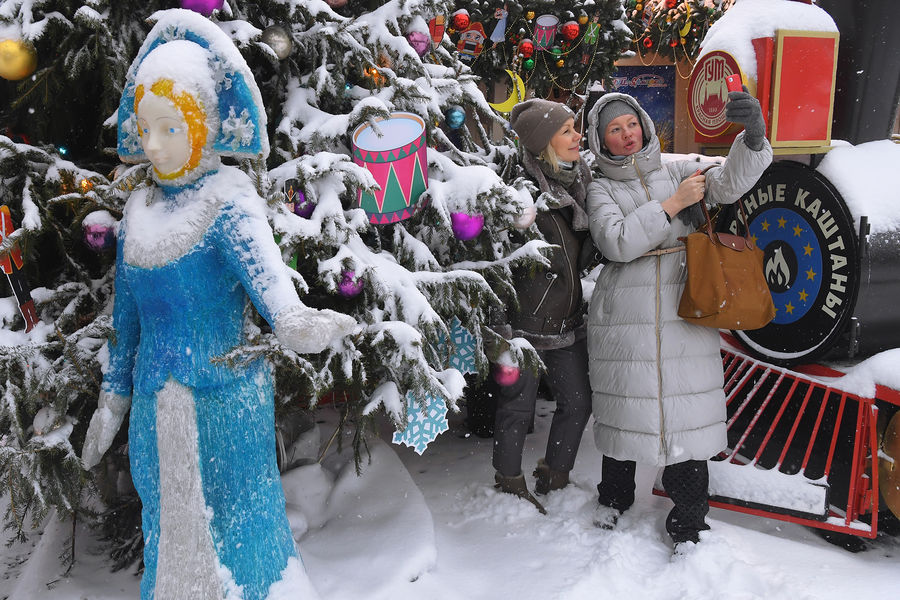 Девушки фотографируются на&nbsp;фоне новогодней елки у&nbsp;ГУМа во время снегопада в&nbsp;Москве, 7&nbsp;декабря 2021&nbsp;года
