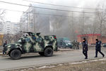 Военный автомобиль у горящего дома на одной из улиц города. В результате обстрела жилых кварталов погибли люди