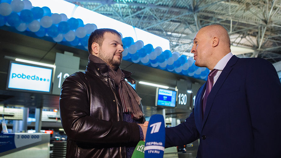 Генеральный директор ООО «Авиакомпания «Победа» Андрей Калмыков поздравляет трехмиллионного пассажира «Победы»