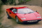 <b>Lamborghini Countach</b> (годы выпуска: 1974&nbsp;- 1990). Дизайн автомобиля разрабатывал&nbsp;Марчелло Гандини, он же ранее разрабатывал дизайн&nbsp;Miura и Jarama. В&nbsp;те годы Гандини был молодым и не очень опытным дизайнером, он мало ориентировался в&nbsp;эргономике&nbsp;автомобиля и оригинальный дизайн Countach&nbsp;&mdash; это его представление автомобиля, практически не искажённое правилами и традициями автомобилестроения. Countach получился угловатым, широким и низким. Фактически корпус состоял из&nbsp;множества трапециевидных плоскостей. Хотя в&nbsp;автомобиле и присутствовали плавные линии, они не смягчали внешней угловатости.<br>
Двери автомобиля, своеобразная визитная карточка Countach, а впоследствии и других моделей Ламборгини, были&nbsp;гильотинного типа&nbsp;(«двери-ножницы»)&nbsp;&mdash; для&nbsp;открытия дверь поднималась и отталкивалась вперёд. Хотя это и оказалось интересным дизайнерским решением, в&nbsp;первую очередь это было сделано из-за большой ширины автомобиля: стандартные двери в&nbsp;данном случае были бы весьма неудобны.