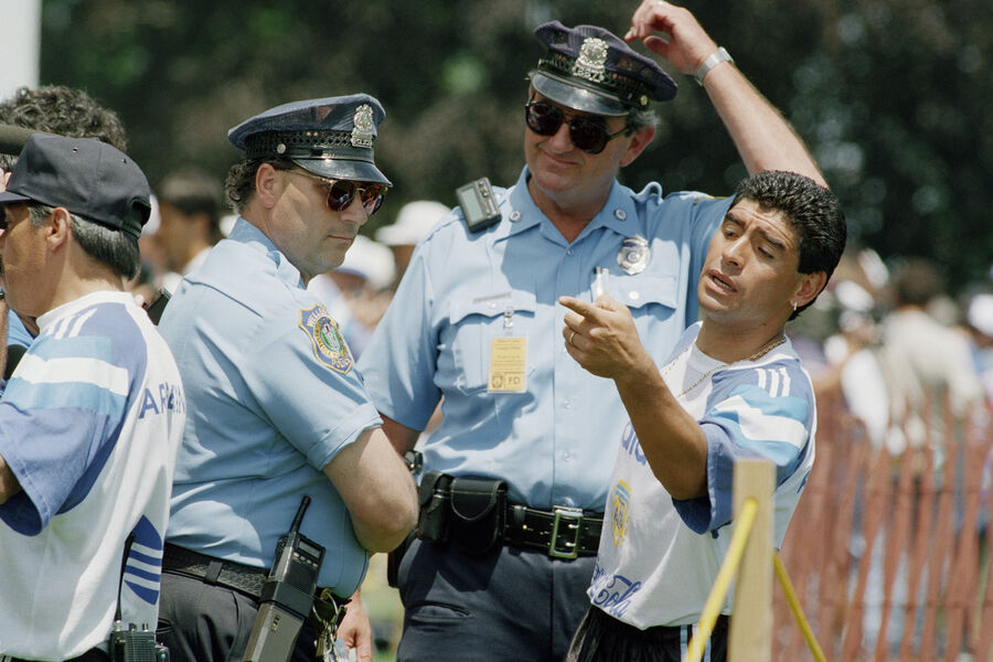 Аргентинский футболист Диего Марадона в сопровождении полиции после провала теста на допинг в Уэллсли, штат Массачусетс, 23 июня 1994 года