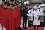 Для первого дня торжеств Елизавета II выбрала белый цвет. На ней было пальто с золотыми и серебряными клепками, а из украшений – жемчужное ожерелье в три нити и серебряная звезда на левом плече.