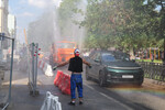 Мужчина охлаждается у поливомоечной машины в Москве, 2 июля 2024 года