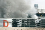 Дым поднимается над одной из парковок в аэропорту Мадрида Барахас после взрыва автомобиля, устроенного предположительно боевиками ЭТА, 30 декабря 2006 года