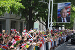 Люди приветствуют кортеж президента РФ Владимира Путина на улице в Пхеньяне, 19 июня 2024 года