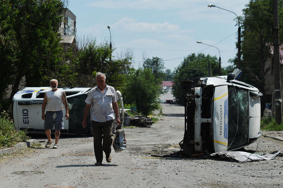 Жители Лисичанска идут по&nbsp;одной из&nbsp;улиц города, июль 2022&nbsp;года