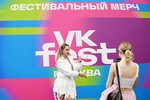 Девушки фотографируются у баннера на фестивале VK Fest 2025 в Москве, 20 июля 2025 года