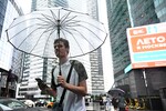 Молодой человек во время ливня в Москве, 15 июля 2025 года