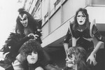 Участники группы Kiss басист Джин Симмонс (слева на заднем плане) и гитарист Эйс Фрейли (справа на заднем плане), вокалист и гитарист Пол Стэнли (слева на переднем плане) и барабанщик Питер Крисс в лондонском аэропорту Хитроу, 12 мая 1976 года