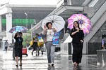 Горожане во время ливня в Москве, 15 июля 2025 года