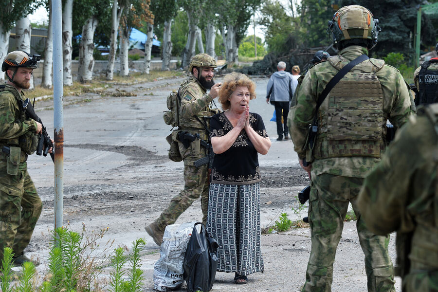 Бойцы специального полка полиции имени Героя России Ахмата-Хаджи Кадырова и жительница Лисичанска на&nbsp;улице города, июль 2022&nbsp;года