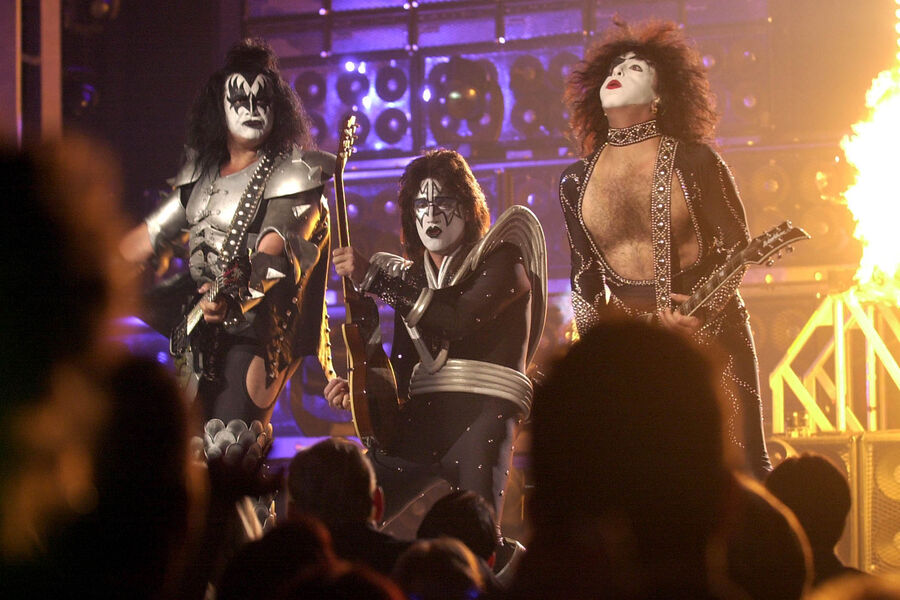 Участники группы Kiss Джин Симмонс (слева), Эйс Фрейли (в центре) и Пол Стэнли (справа) выступают во время записи концерта, посвященного 50-летию American Bandstand в&nbsp;Пасадене, Калифорния, 19&nbsp;апреля 2002&nbsp;года 