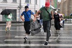 Горожане во время ливня в Москве, 15 июля 2025 года