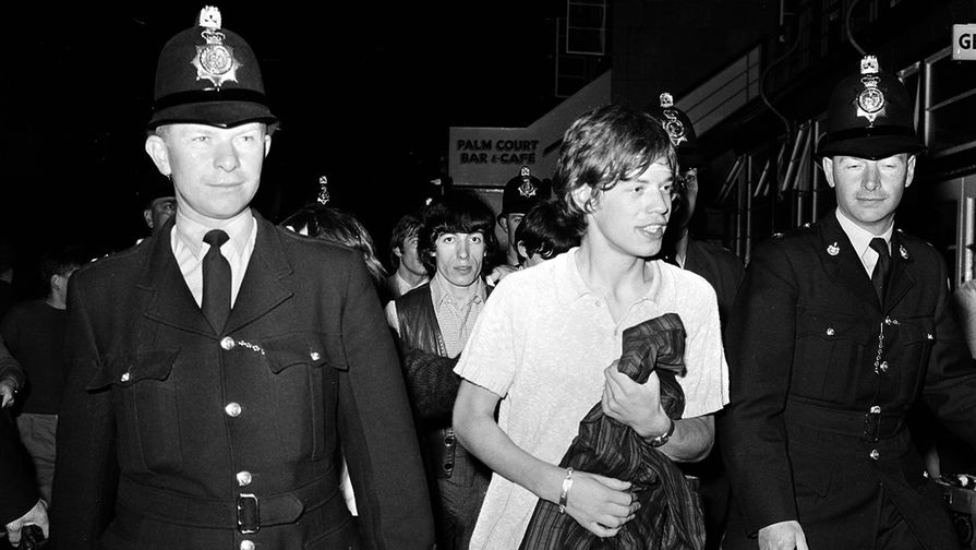 Мик Джаггер и члены The Rolling Stones в сопровождении полиции после концерта в британском Гастингсе, 1964 год