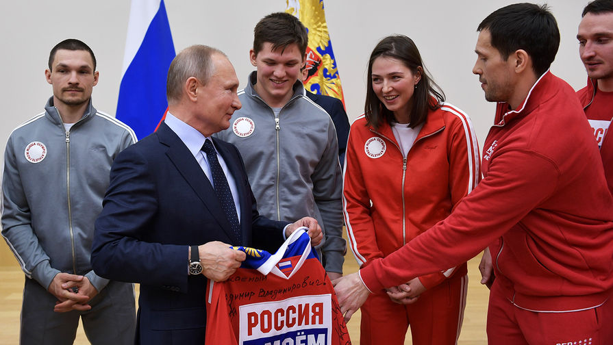 Владимир Путин во время встречи с российскими спортсменами – участниками XXIII Олимпийских зимних игр 2018. Справа на первом плане - капитан сборной России по хоккею Павел Дацюк вручает президенту свитер команды от олимпийских спортсменов, 31 января 2018 года