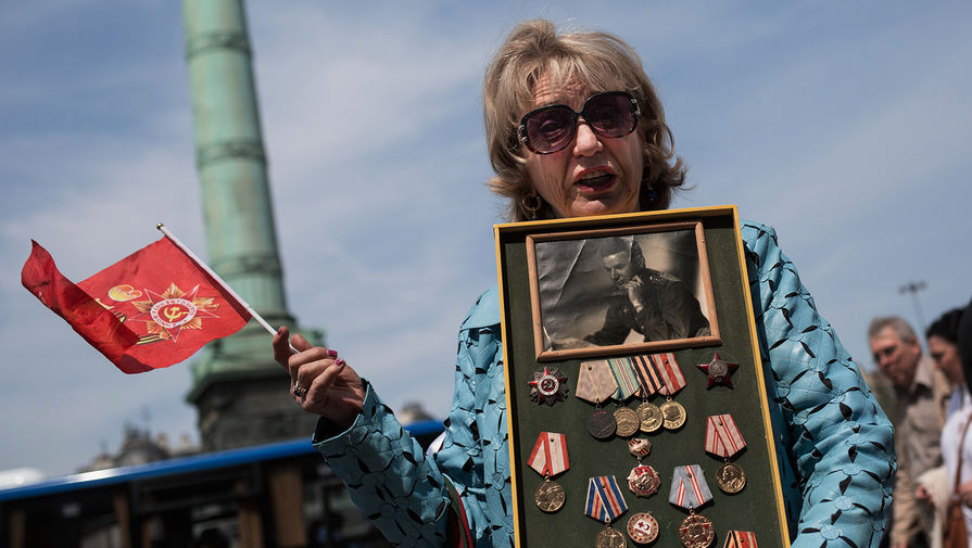 2841606 8.05.2016. Участница марша «Бессмертный полк» на площади Бастилии у здания Оперы Бастилия в Париже