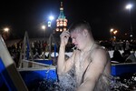 Верующий во время крещенских купаний на берегу Енисея возле Свято-Никольского храма-памятника в Красноярске, 19 января 2025 год