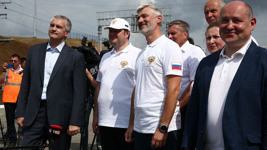 Глава Республики Крым Сергей Аксенов (слева), министр транспорта РФ Евгений Дитрих (в центре) и временно исполняющий обязанности губернатора Севастополя Михаил Развозжаев (справа) на церемонии открытия грузового железнодорожного сообщения по Крымскому мосту, 30 июня 2020 года