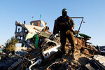 Палестинский боевик ХАМАС стоит на руинах здания перед освобождением заложников в рамках соглашения о прекращении огня и обмена заложниками и заключенными между ХАМАС и Израилем в Хан-Юнисе, на юге сектора Газа, 15 февраля 2025 года
