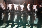 Силуэты полицейских на фоне горящей баррикады во время митинга против экономической и социальной политики президента Дины Болуарте в Лиме, Перу, 28 сентября 2025 года