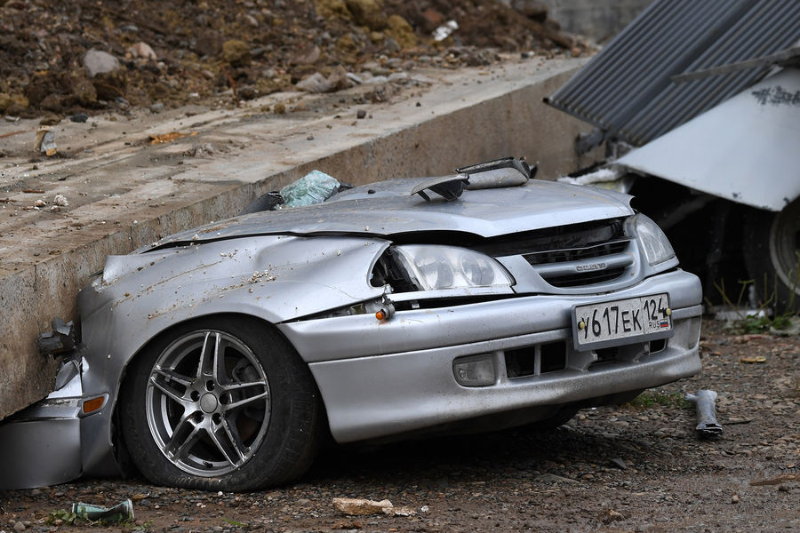 Легковой автомобиль, раздавленный обрушившейся подпорной стеной возле, жилого дома на проспекте 60-летия образования СССР в Красноярске, 6 августа 2021 года