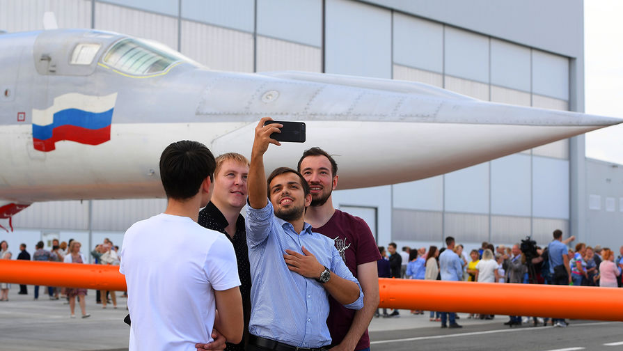 5610710 16.08.2018 Сотрудники завода делают селфи на&nbsp;фоне самолета во время презентации в&nbsp;Казани, 16 августа 2018 года