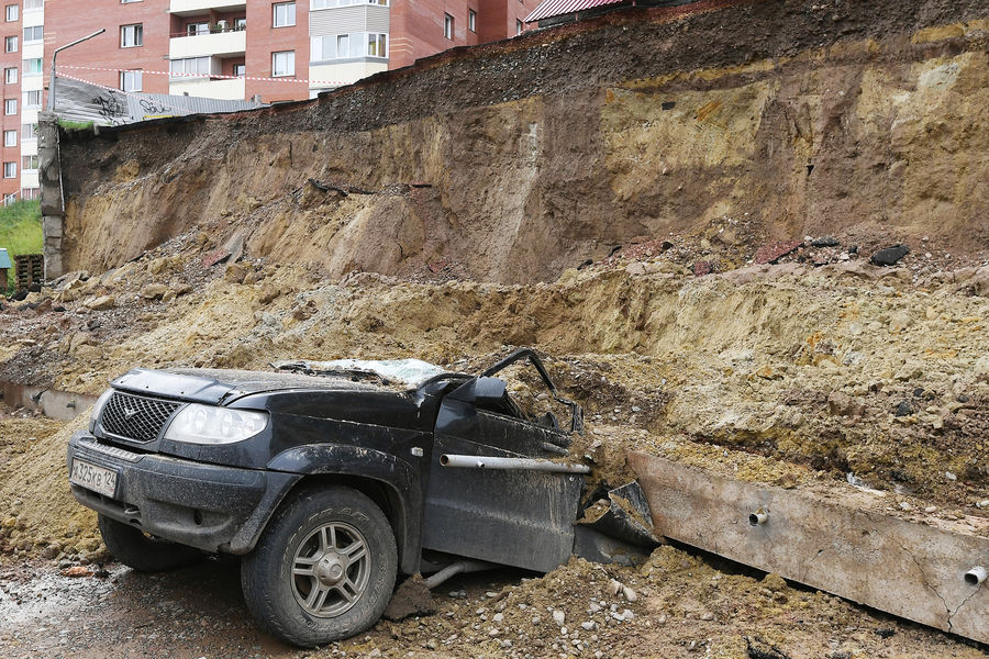 Легковой автомобиль, раздавленный обрушившейся подпорной стеной, возле жилого дома на проспекте 60-летия образования СССР в Красноярске, 6 августа 2021 года