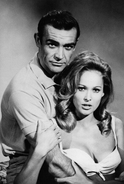 <b>Бондиана (1962-1983)</b>
<br><br>
На&nbsp;момент старта величайшей шпионской франшизы в&nbsp;истории кино Коннери был фактически ноунеймом &mdash; актерством британец начал всерьез заниматься лишь за&nbsp;несколько лет до&nbsp;этого, сыграв в&nbsp;фильмах &laquo;Адские водители&raquo;, &laquo;Другое время, другое место&raquo;, &laquo;Дарби О'Гилл и маленький народ&raquo;, а также &laquo;Анна Каренина&raquo;, причем не удостоился за&nbsp;эти роли какой-то выдающейся критики. Во время кастинга экранного Бонда создатель персонажа Ян Флеминг был против его кандидатуры, подчеркивая, что видит в&nbsp;Коннери не того самого спецагента, а &laquo;каскадера-переростка&raquo;. На&nbsp;финальное решение, как стало известно позднее, повлияла женская половина продюсерской команды, уверенная, что актер станет не просто идеальным 007, но и секс-символом эпохи.
<b>На фото:</b> актеры Шон Коннери и Урсула Андресс в&nbsp;фильме бондианы &laquo;Доктор Ноу&raquo; (1964)
