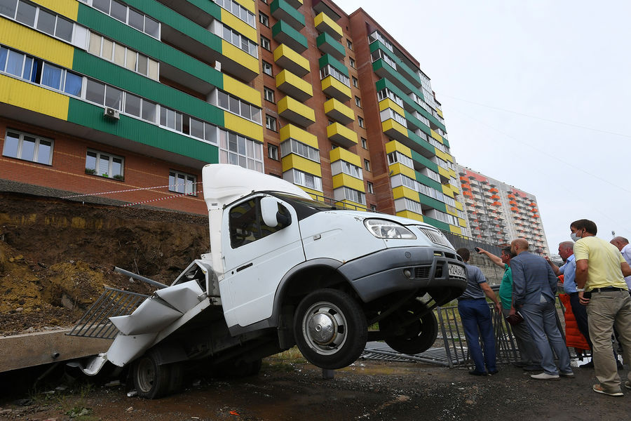 Специалисты осматривают место обрушения подпорной стены возле жилого дома на проспекте 60-летия образования СССР в Красноярске, 6 августа 2021 года