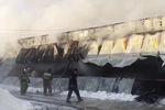 Сотрудники пожарной службы МЧС РФ во время тушения пожара в здании с обувным производством в поселке Чернореченский Искитимского района Новосибирской области, 4 января 2018