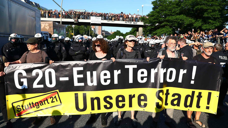 Протестующие с плакатом «G20 — ваш террор, наш город!» во время демонстрации накануне саммита G20 в Гамбурге, 6 июля 2017 года