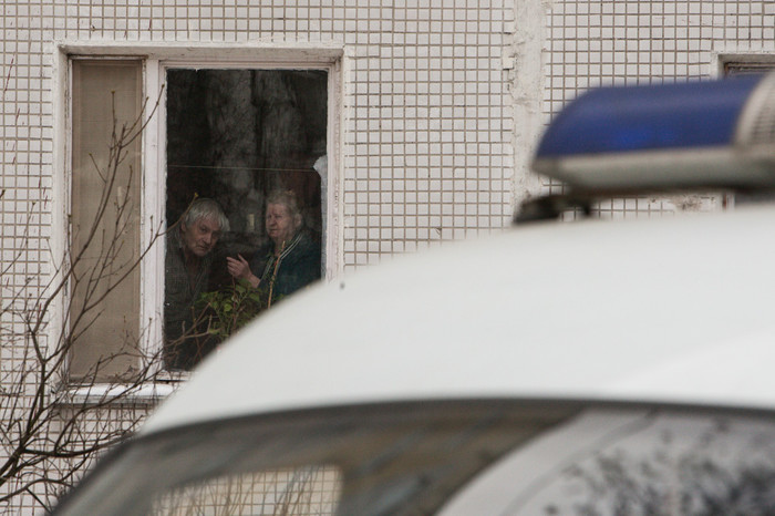 Жители дома напротив наблюдают за ситуацией у школы №263