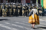 Женщина проходит мимо военной полиции на площади Мурильо в Ла-Пасе, Боливия, 27 июня 2024 года
