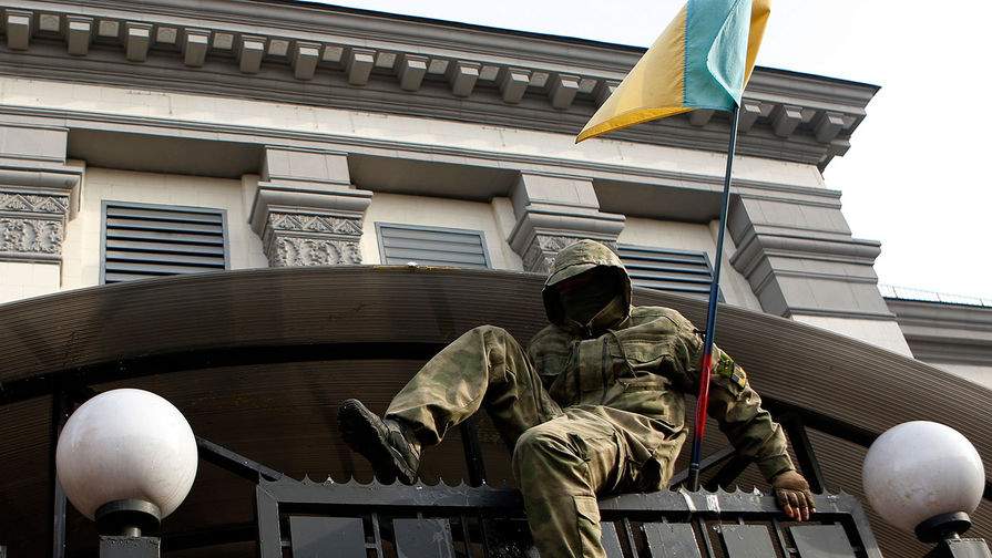 Участник митинга за&nbsp;освобождение украинской летчицы Надежды Савченко перелезает через&nbsp;забор посольства России в&nbsp;Киеве