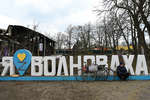 Житель Волновахи у стелы с названием города, март 2022 года