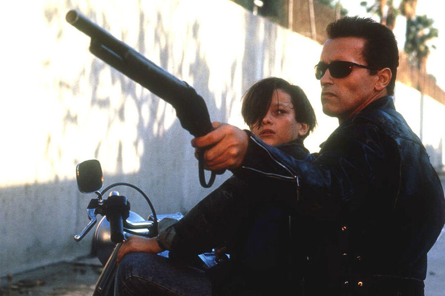 <b>«Терминатор: Судный день» (1991)</b>
<br><br>
После того, как в&nbsp;1984 году сети Skynet не удалось убить Сару Коннор (в исполнении Линды Хэмилтон), уже нового, продвинутого киборга отправляют в&nbsp;1995 год &mdash; чтобы расправиться с&nbsp;ее сыном, будущим лидером человеческого сопротивления Джоном Коннором. К&nbsp;этому моменту Сару Коннор уже упрятали в&nbsp;больницу из-за ее безумных попыток предотвратить Судный день 1997&nbsp;года, когда Skynet обретет власть над&nbsp;миром. Сын живет с&nbsp;приемными родителями и тоже не верит маме. Попытку киборга убить мальчика предотвращает старый Терминатор-Шварценеггер, перешедший на&nbsp;сторону людей.
<br><br>
Фильм был обласкан критиками, которые назвали его визуальные спецэффекты революционными, и принес в&nbsp;общей сложности $520 млн. Любопытно, что изначально Джеймс Кэмерон продолжение первого «Терминатора» снимать не хотел &mdash; он был уверен, что история закончена. А вот Арнольд Шварценеггер был уверен с&nbsp;самого начала, что картине необходим сиквел. Следующий фильм о&nbsp;Терминаторе &mdash; «Терминатор: Восстание машин», вышедший в&nbsp;2003-м, &mdash; снял уже не Кэмерон.
