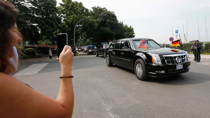 Женщина фотографирует кортеж президента США Дональда Трампа