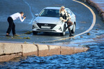 Парень фотографирует девушку у автомобиля на фоне Невы, 11 октября 2025 года
