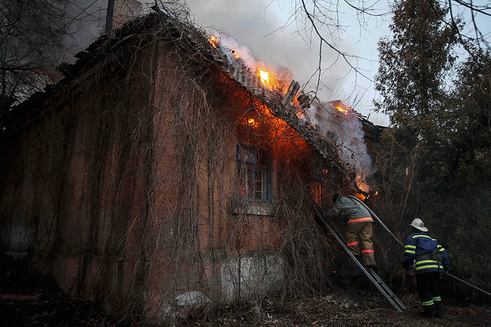 Пожарные гасят пожар в&nbsp;здании после обстрела