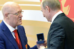 Президент России Владимир Путин и президент всероссийского клуба юных хоккеистов «Золотая шайба» Владимир Петров во время заседания Совета при президенте России по развитию физической культуры и спорта, апрель 2016 года