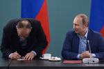 Президент России Владимир Путин (справа) и тренер сборной команды России по дзюдо Эцио Гамба во время встречи. Э. Гамба расписывается в полученном паспорте гражданина РФ
