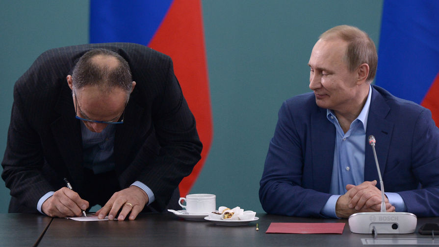 Президент России Владимир Путин (справа) и тренер сборной команды России по дзюдо Эцио Гамба во время встречи. Э. Гамба расписывается в полученном паспорте гражданина РФ
